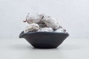 Dried persimmon fruits in black bowl. High quality photo
